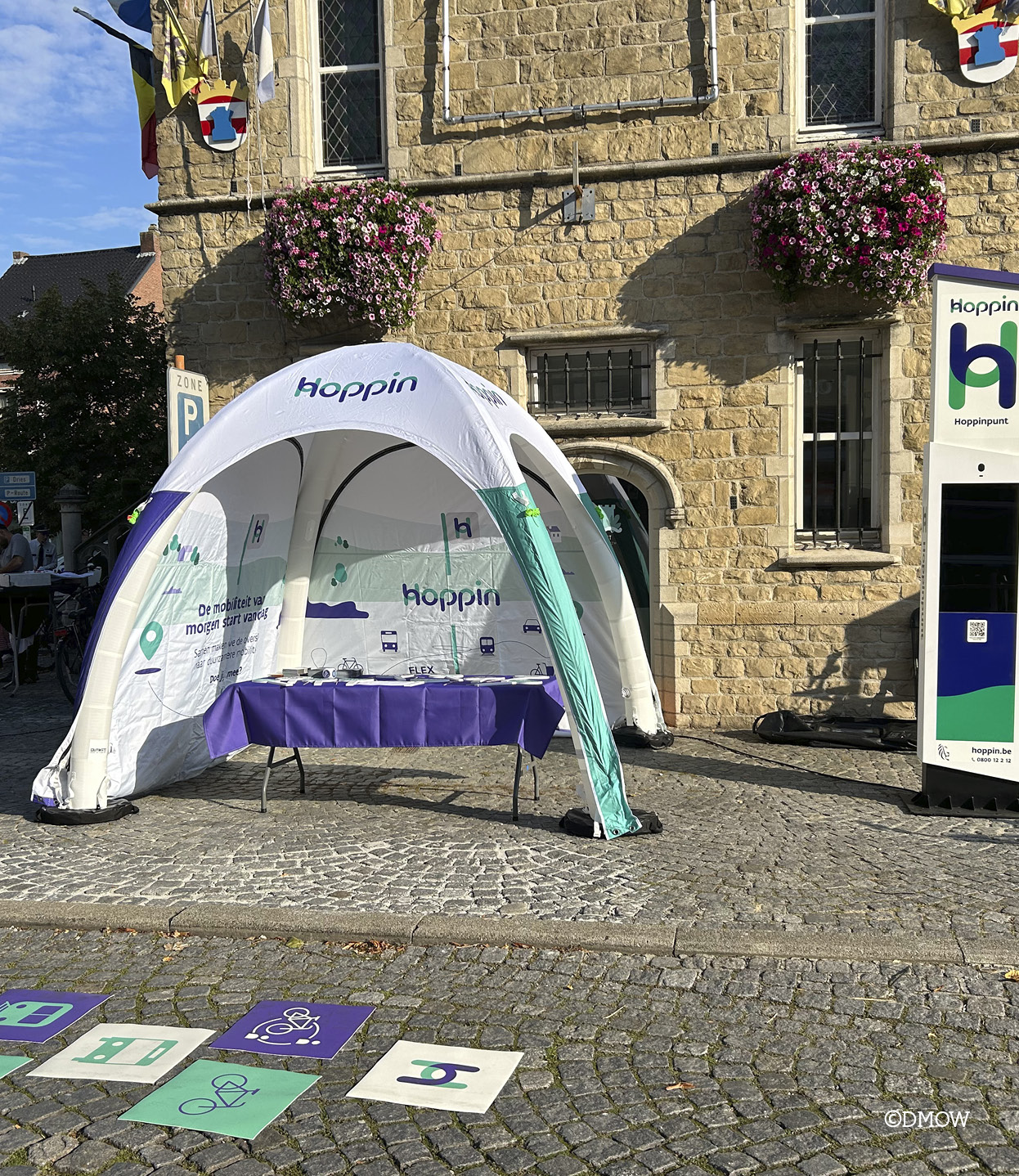 Kerkplein in Bornem waar de Hoppin-tent en het Hoppinhinkelparcour staan om mensen te informeren over deelsystemen 